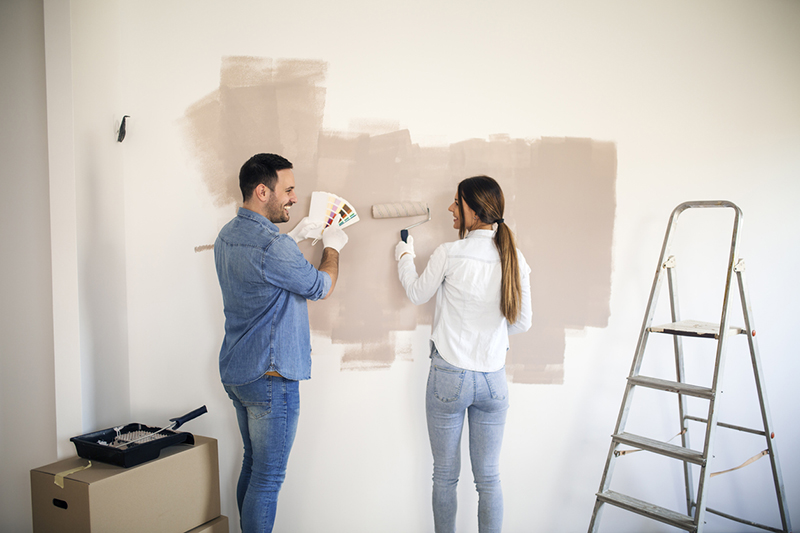 Couple painting the interior wall of their home
